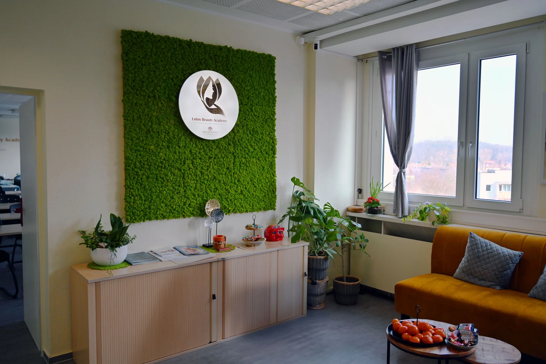 Empfangsbereich mit Mooswand und Lotus Beauty Academy Logo